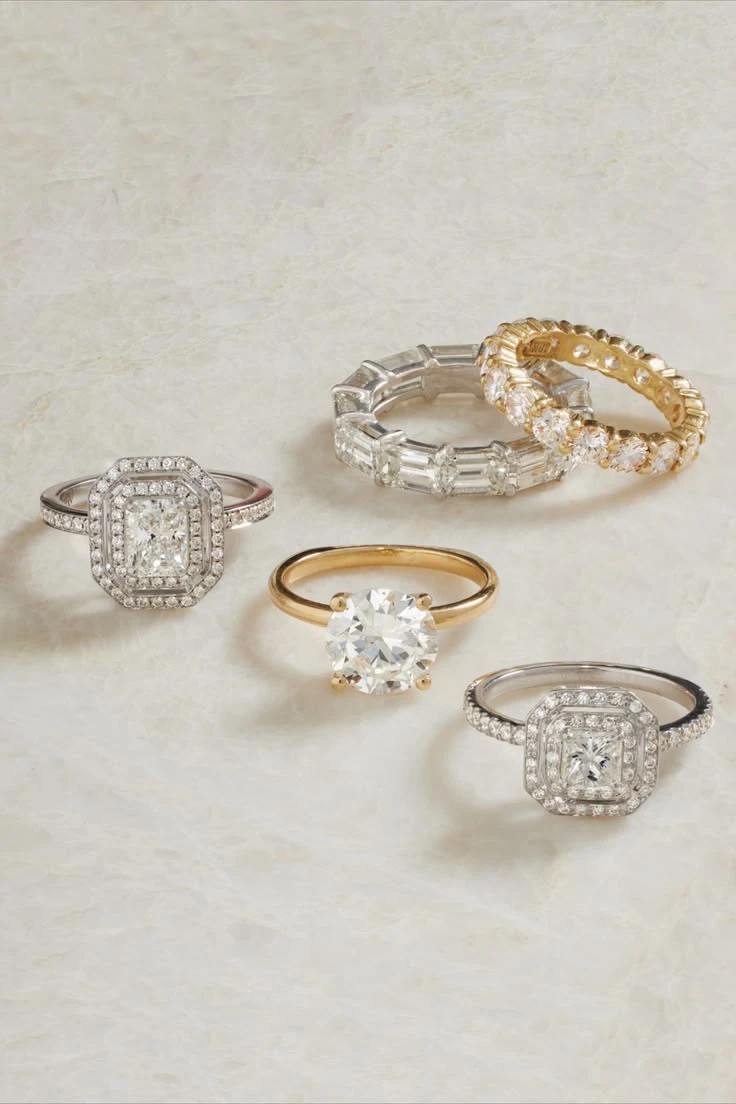 Gold and white-metal rings arranged on a light textured surface